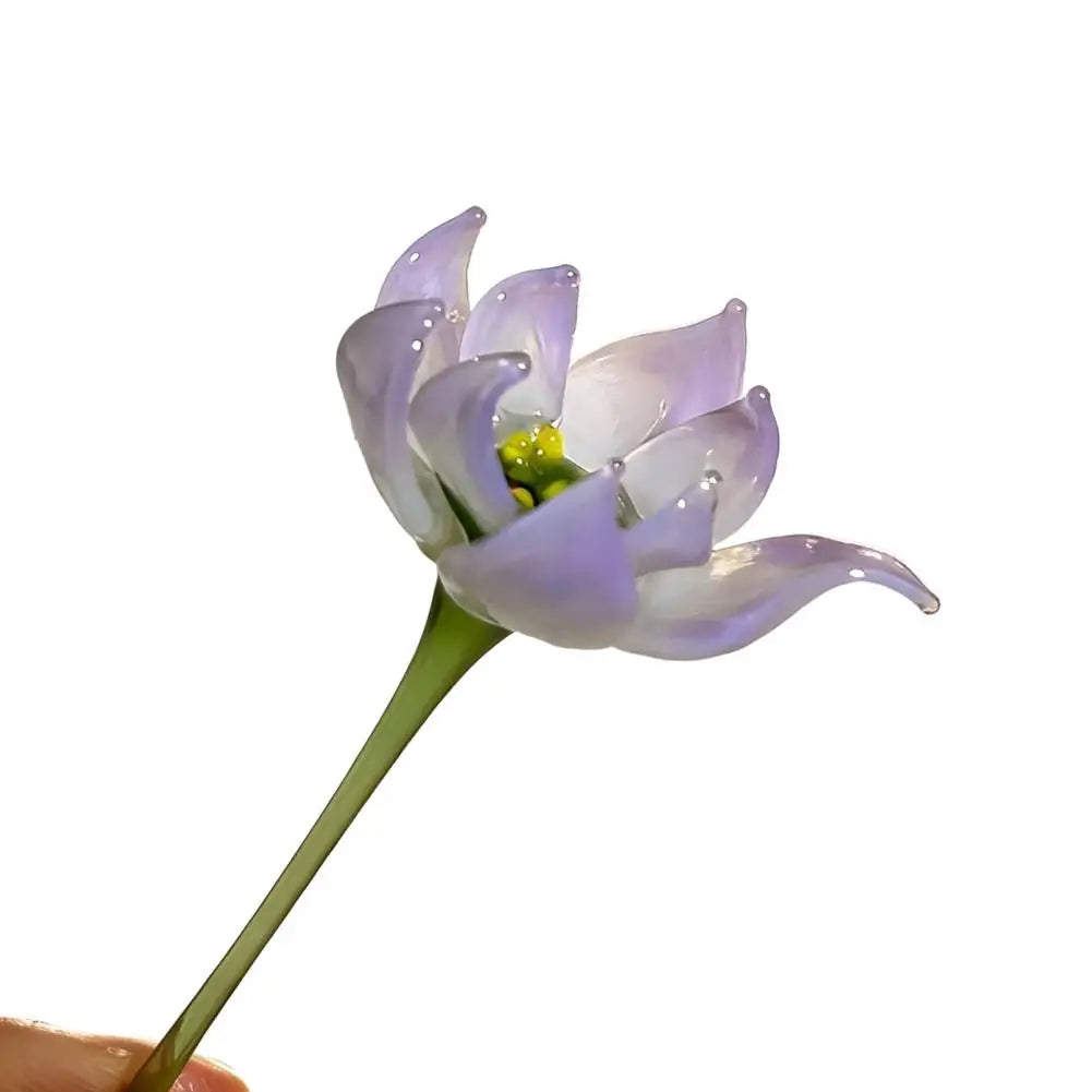 A handcrafted blue glass flower sculpture with purple petals and a green stem.