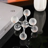 A minimalist molecular sculpture desk decor featuring clear glass spheres arranged in a branching structure.