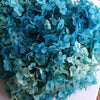 A close-up of a bouquet of blue-green dried hydrangea florets used for home decor.