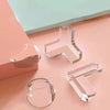 Clear silicone corner protectors for baby safety displayed on a pink surface.