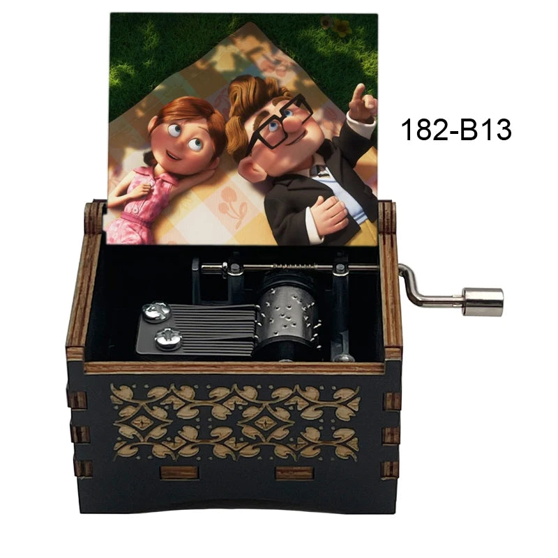 A wooden music box with a hand crank, featuring an illustration of a couple and gold leaf detailing.