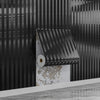 A close-up of metallic gold striped peel-and-stick wallpaper installed on a dark, vertically striped wall.