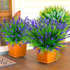 A vibrant arrangement of artificial lavender and green flowers in orange pots