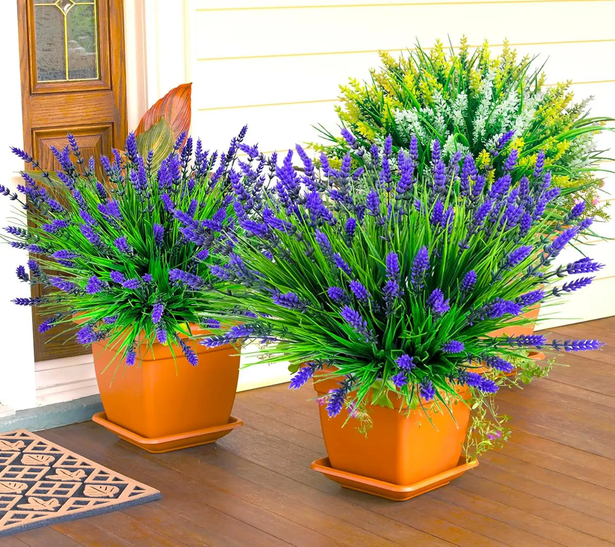 A vibrant arrangement of artificial lavender and green flowers in orange pots