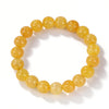 A bracelet made of small, round, yellow-orange citrine crystals.