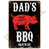 A dark metal sign with white text reading Dad's World Famous BBQ King Of The Grill