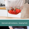 Clear plastic food wrap covers being used to seal and preserve fresh vegetables and meat.