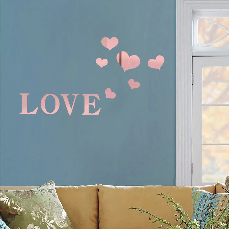 Pink heart wall stickers spelling LOVE on a blue wall next to a window