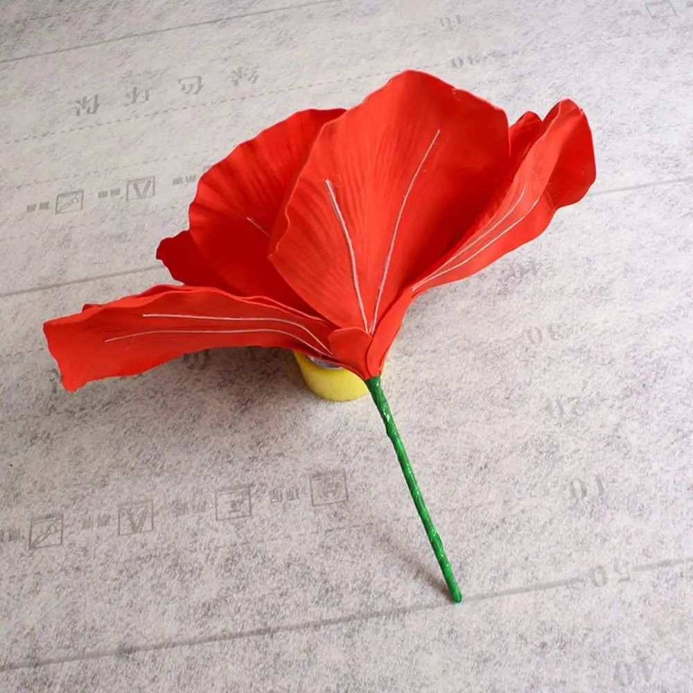 A vibrant red silk foam rose with a green stem, used for home and event decoration.