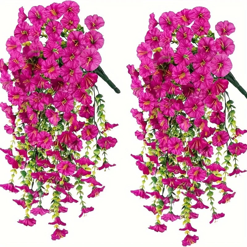 Two bunches of artificial pink morning glory flowers with green eucalyptus leaves used for hanging decor