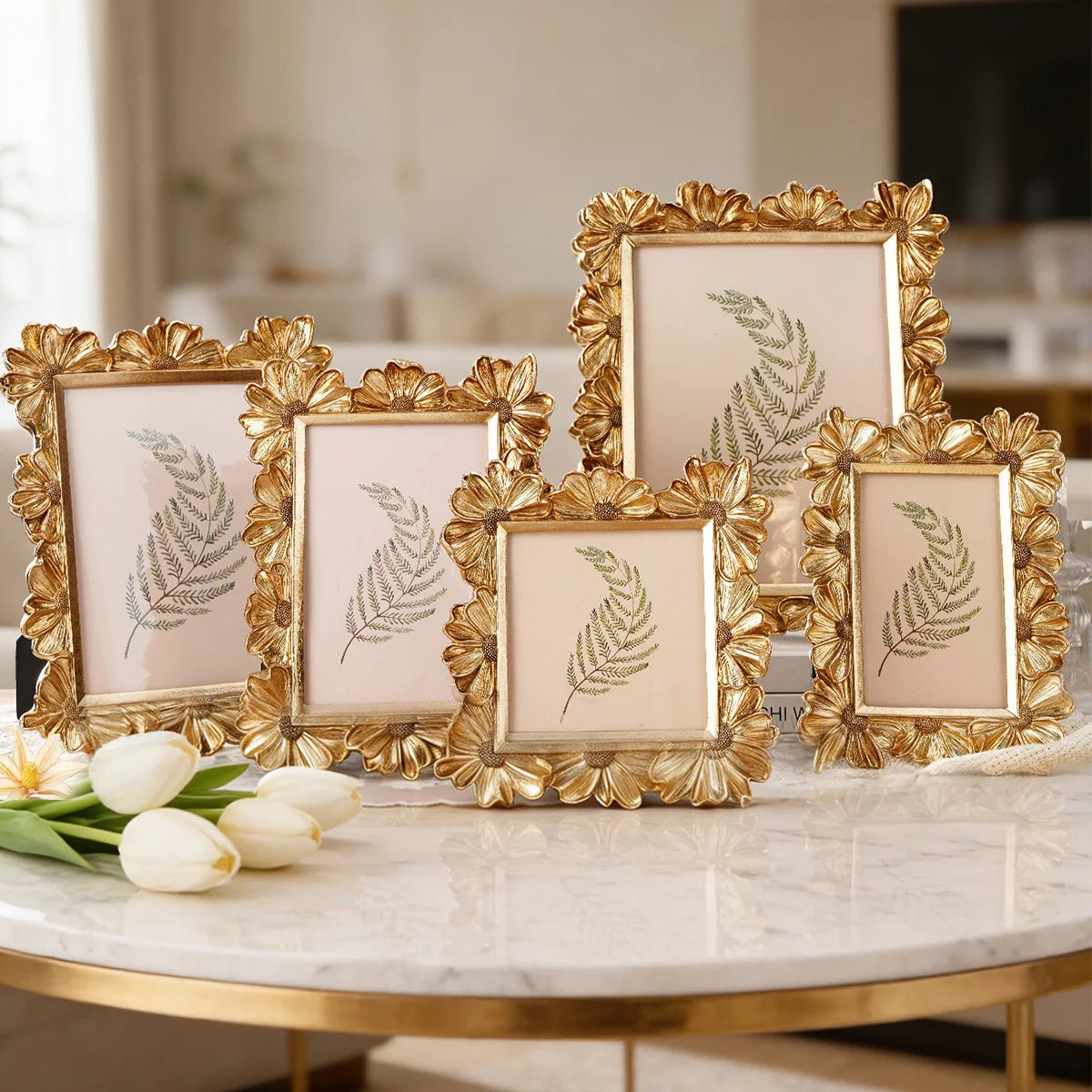 A collection of golden 3D resin photo frames with floral accents displayed on a marble table.