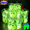 A jar filled with glow-in-the-dark resin alien cat and duck charms, packaged for sale.
