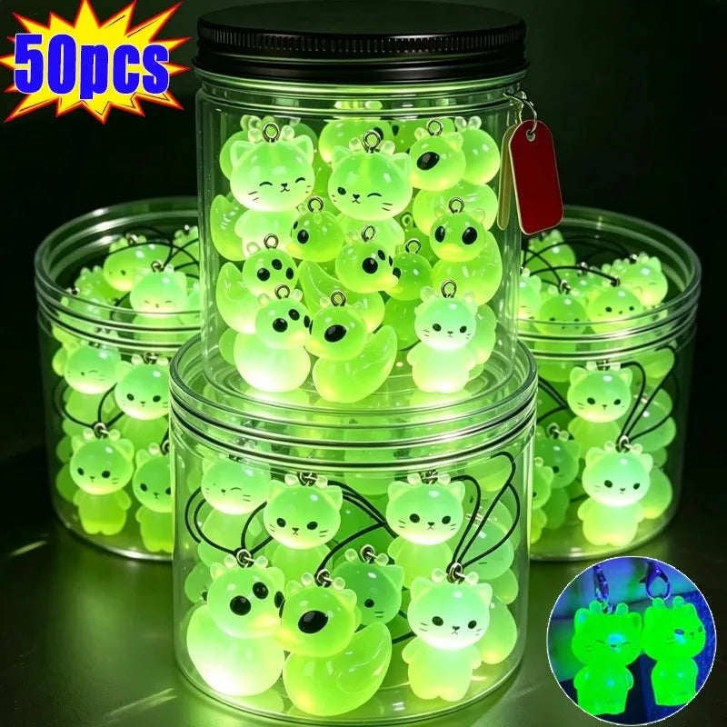 A jar filled with glow-in-the-dark resin alien cat and duck charms, packaged for sale.