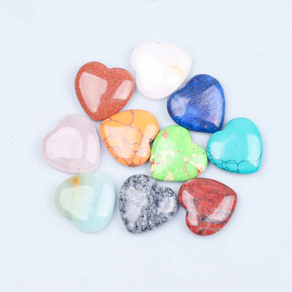 A collection of heart-shaped amethyst crystal stones in various colors including pink, orange, blue, and green.