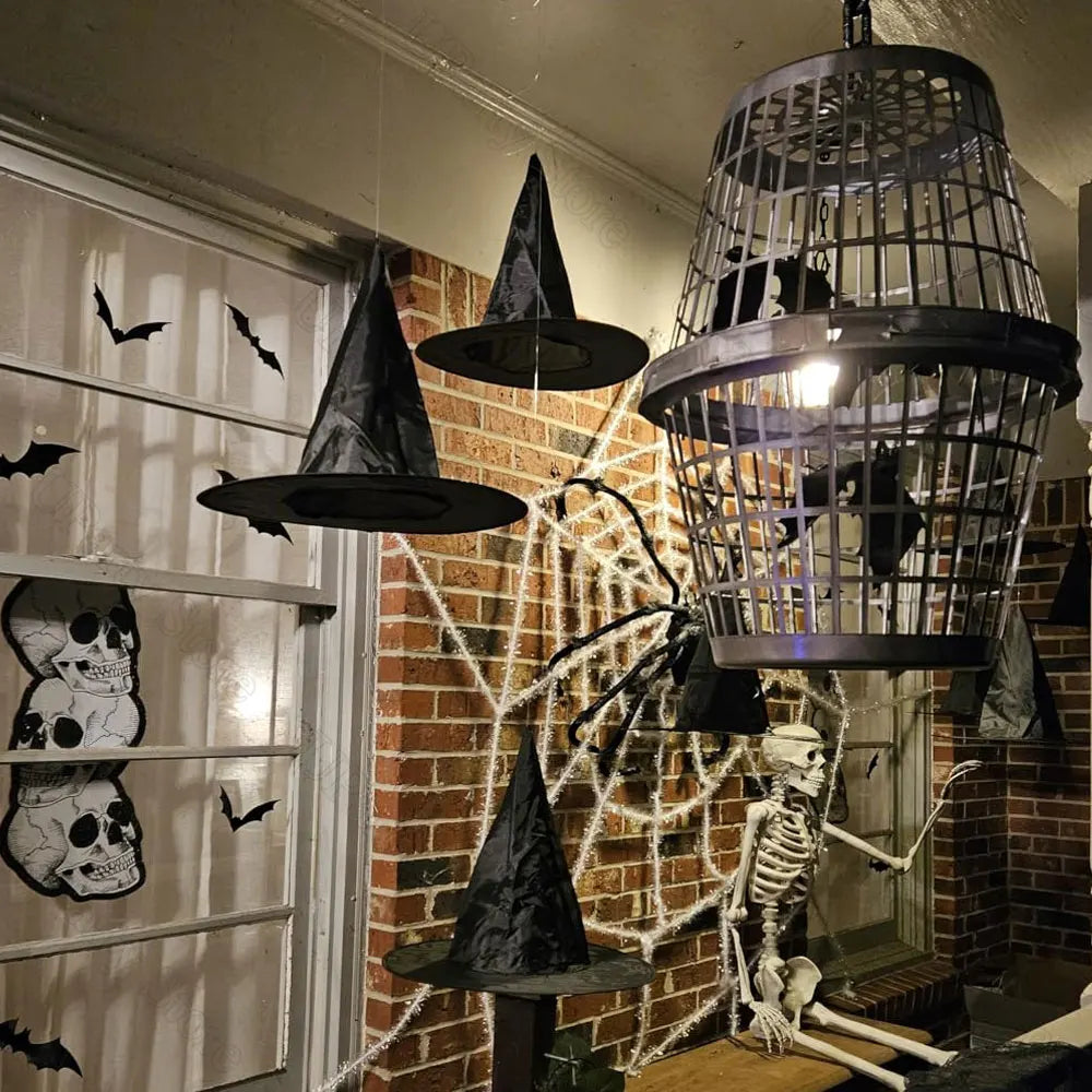 Classic black witch hats with hanging rope used as Halloween décor against a brick wall.