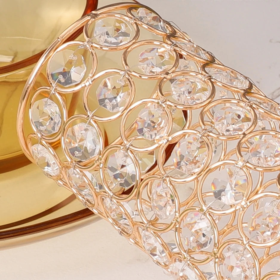 A close-up of a crystal gold flower vase featuring intricate, round-cut glass detailing.