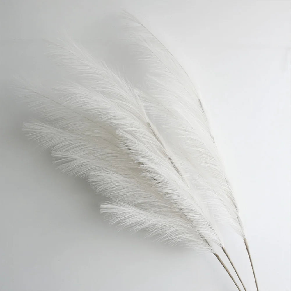 A close-up of white artificial pampas grass branches used for boho home and wedding decor.