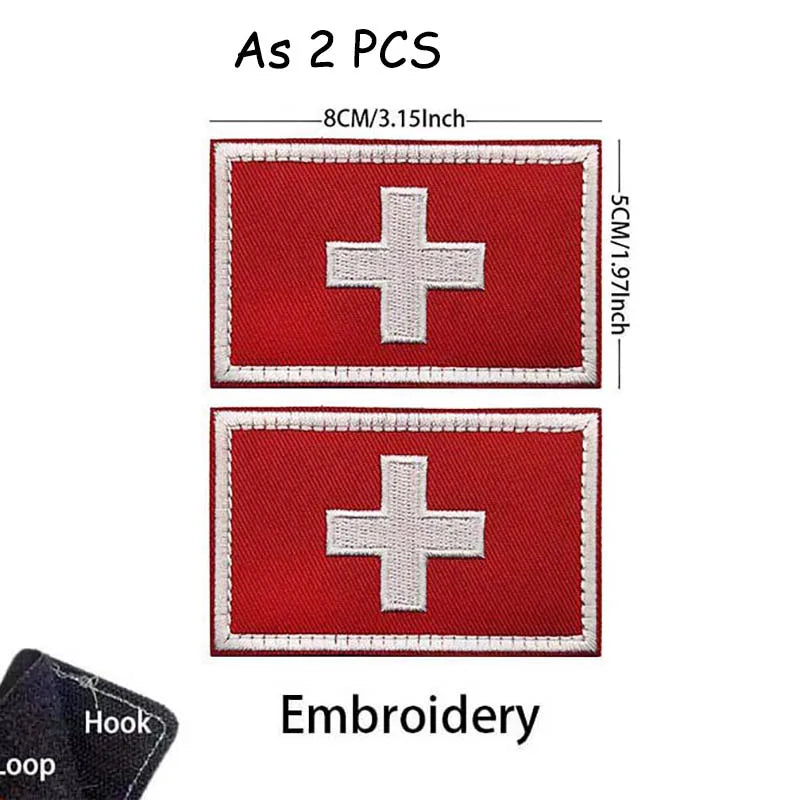 Two red embroidered medical cross patches with white borders and stitching