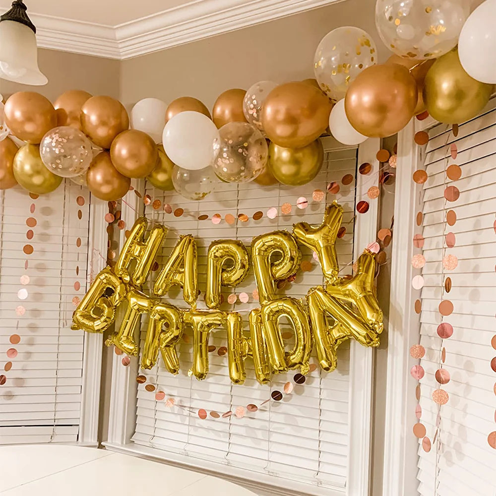 A golden balloon arch decoration featuring gold and white balloons for a birthday party.
