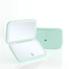A light mint green portable touch screen makeup mirror with a hinged design and LED lighting.