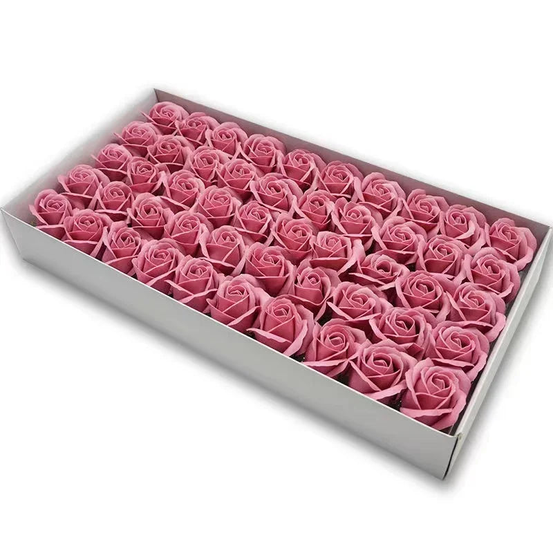 A rectangular box filled with pink artificial rose flower heads for DIY crafts and decor.
