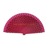 A fan made of pink wooden slats with black dots, used for dance or parties.