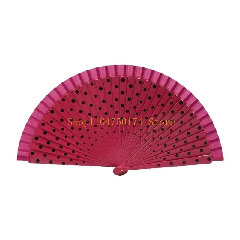 A fan made of pink wooden slats with black dots, used for dance or parties.