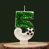 A decorative candle shaped like the number 5, covered in green glitter, with a soccer ball detail on the bottom.