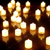 A row of glowing white LED tea light candles arranged on a dark reflective surface.