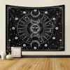 A black tapestry wall hanging featuring a white psychedelic sun and moon mandala design with stars and celestial elements.