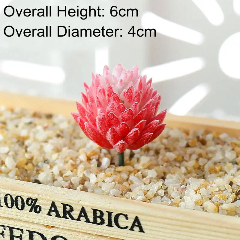 A vibrant pink and red artificial succulent bonsai ball is displayed in a wooden box with gravel.