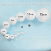 A collection of white polystyrene foam balls of various sizes, ranging from 5cm to 15cm, displayed on a light blue surface.