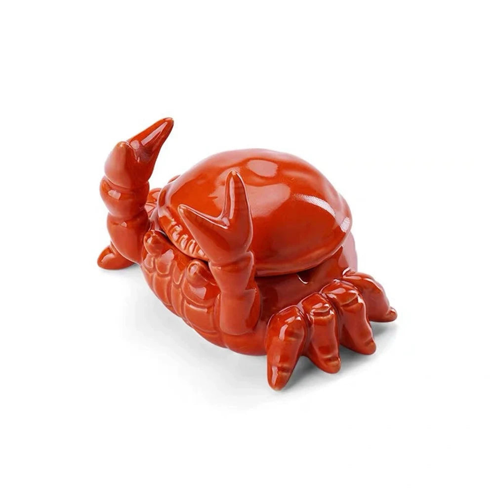 An orange ceramic crab ashtray with a lid.