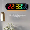 Reloj de pared digital iridiscente RGB mostrando 22:38 y 18°C en una pared gris.