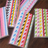 A close-up view of a pack of colorful striped and polka dot paper drinking straws in various vibrant colors.