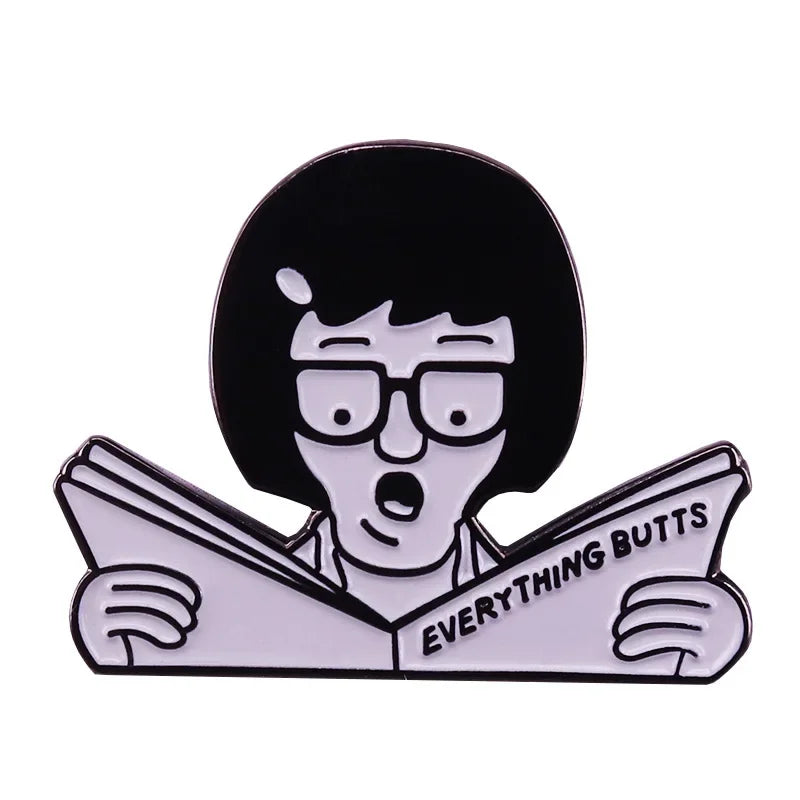 A black enamel pin badge featuring a cartoon character with short black hair looking surprised while reading a newspaper.