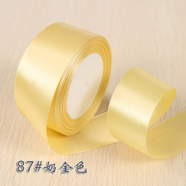 A roll of golden yellow silk satin ribbon for gift wrapping and craft projects.