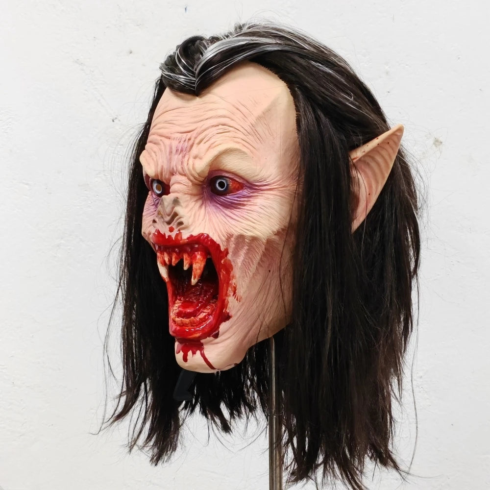 Lifelike vampire mask of an elderly woman with pale skin, bloody fangs, and long black hair.