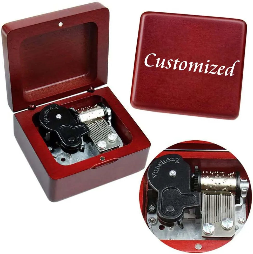 A red wooden music box with an open lid showing the internal mechanism and a separate red box labeled Customized