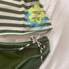 A striped sleeveless top featuring a white and dark green pattern with yellow and blue floral accents.
