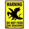 A vintage yellow warning sign with black text and a silhouette of a dragon, instructing not to feed the dragons.