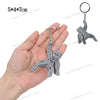 A silver-colored collectible figurine of Rocky and Grace, shaped like starfish, being held in a hand.