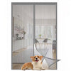 A golden and white dog is lying down in front of a modern gray magnetic automatic screen door curtain.