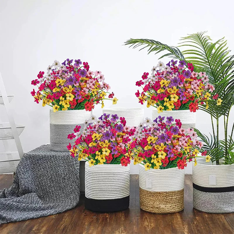A collection of mixed color artificial flowers in various shades of pink, purple, yellow, and green displayed in white and na