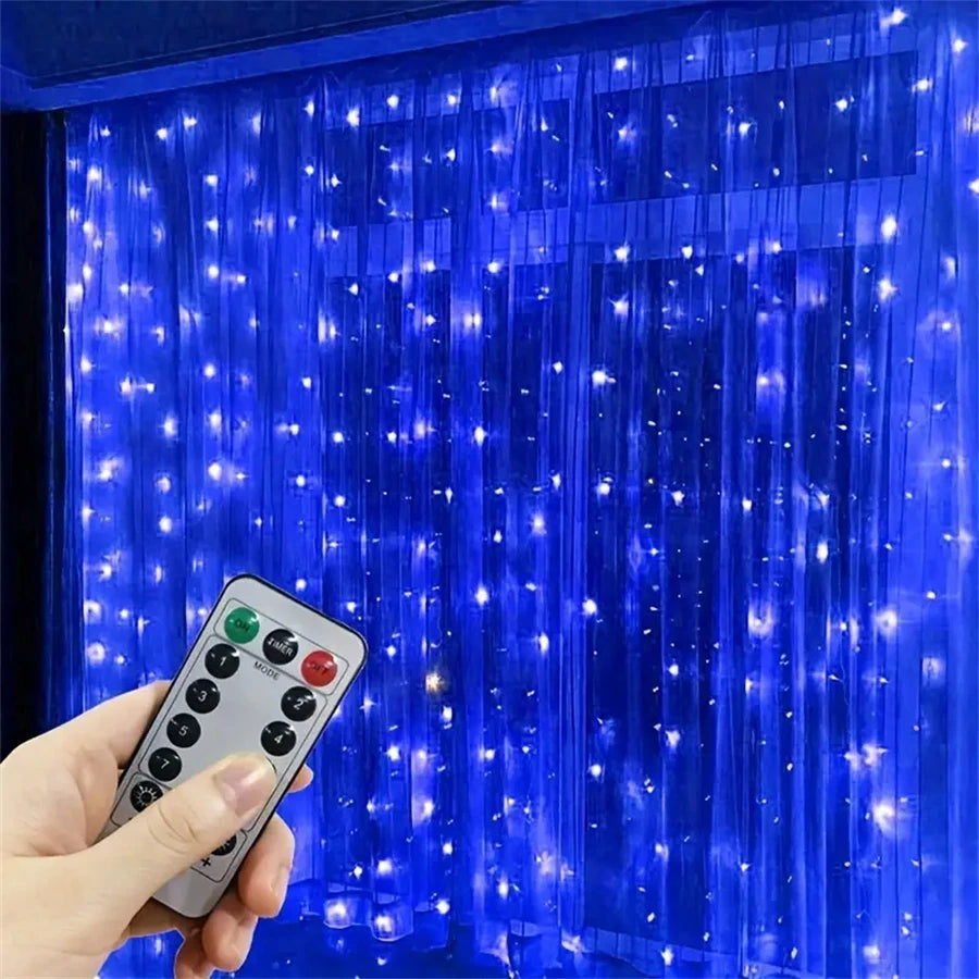 A hand holds a remote control for LED curtain string lights illuminating a blue curtain.