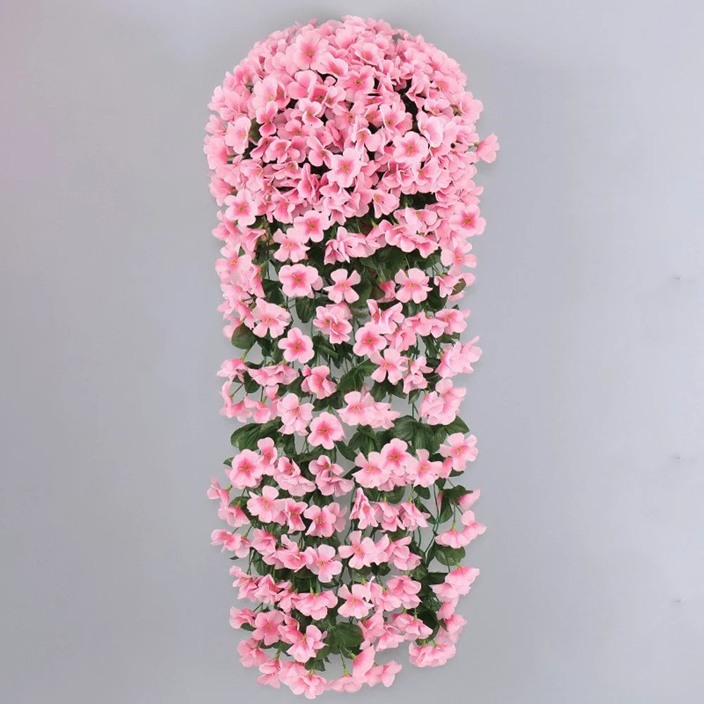 A vertical hanging garland made of pink artificial violet ivy flowers for home decor or weddings.