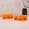 A set of six orange Halloween-themed LED candle lights with carved jack-o'-lantern faces arranged in a row.
