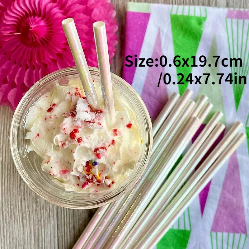 A glass bowl filled with a creamy white substance topped with pink and red sprinkles, next to a bundle of clear drinking stra