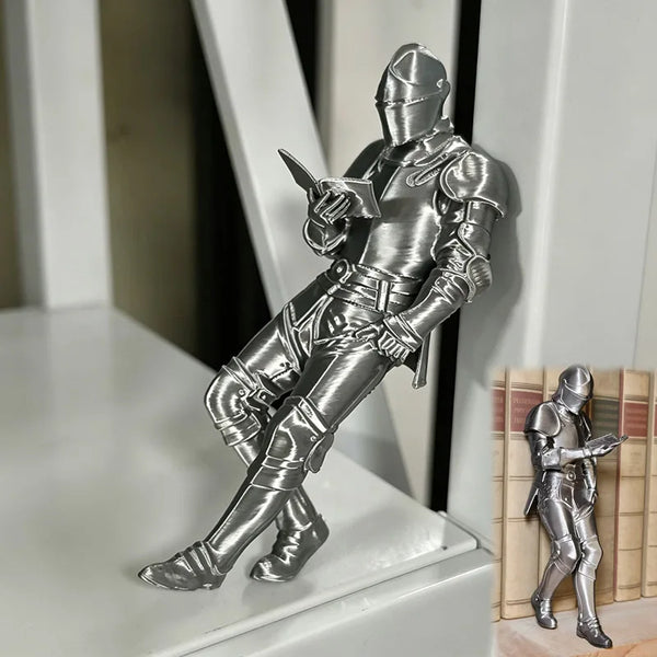 Silberfarbige Figur eines mittelalterlichen gepanzerten Ritters, der ein Buch liest.