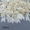 A collection of 50 ivory or cream satin ribbon bows and ties for gift wrapping and decoration.